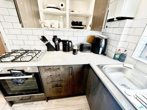 a kitchen with a sink and a stove top oven at Watford Central Luxury Serviced Accommodation in Watford