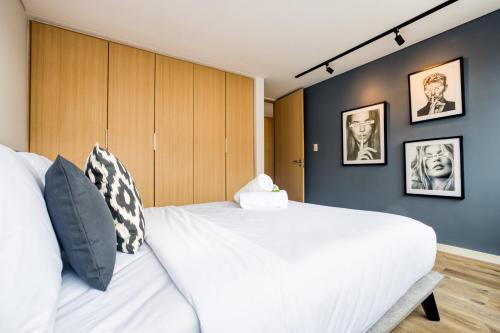 a bedroom with a large white bed and blue walls at ULIV Family Apartments Polanco in Mexico City
