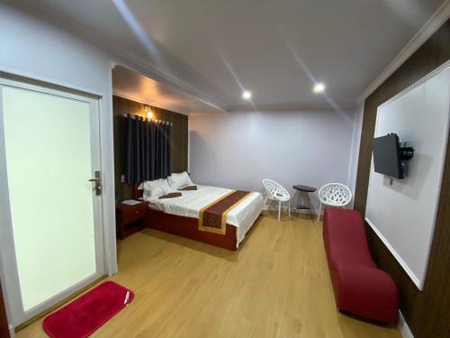 a bedroom with a bed and a red chair at Motel Happy House- Hảo in Bạc Liêu