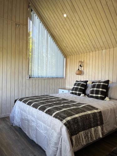 1 dormitorio con 1 cama grande en una habitación en AncudLodge en Ancud