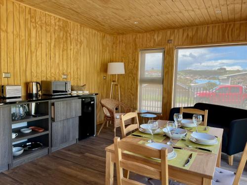 a kitchen and dining room with a table and chairs at AncudLodge in Ancud
