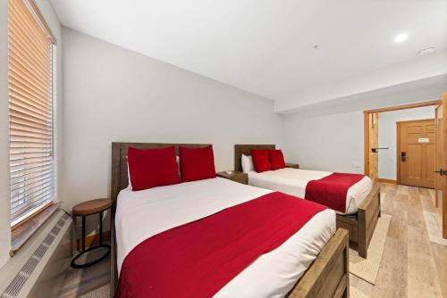 two beds in a room with red pillows at Palisades Tahoe Lodge Rentals Premium Two Bedroom #700 in Olympic Valley
