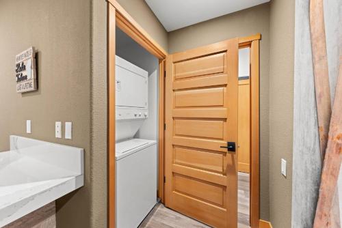 a small kitchen with a door and a refrigerator at Palisades Tahoe Lodge Rentals Premium Two Bedroom #700 in Olympic Valley