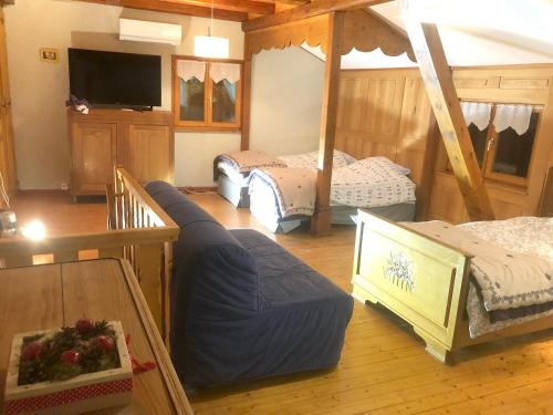 a room with three beds and a flat screen tv at Maison de 6 chambres avec jardin amenage et wifi a Sainte Croix aux Mines in Sainte-Croix-aux-Mines