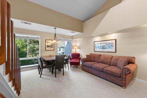 a living room and dining room with a couch and a table at Palisades Tahoe Lodge Rentals Premium Studio Loft #313 in Olympic Valley