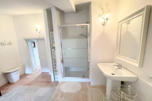 uma casa de banho branca com um chuveiro e um lavatório. em Adam House - Exc Pool em Marzolini