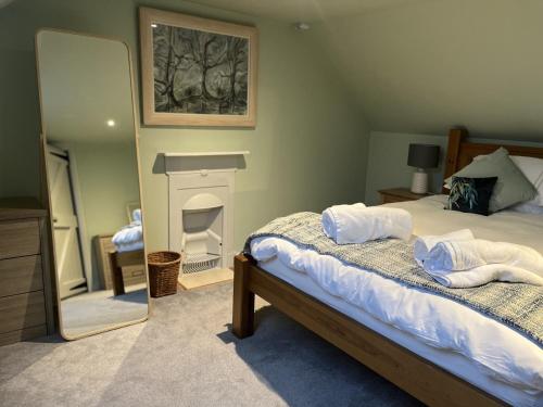 a bedroom with a bed with a fireplace and a mirror at Apple Cottage in Newton Stewart
