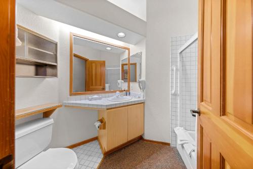 a bathroom with a sink and a toilet and a mirror at Palisades Tahoe Lodge Rentals Two Bedroom #521 in Olympic Valley