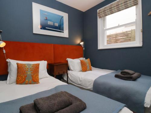 a small room with two beds and a window at Kestrel in Southwold