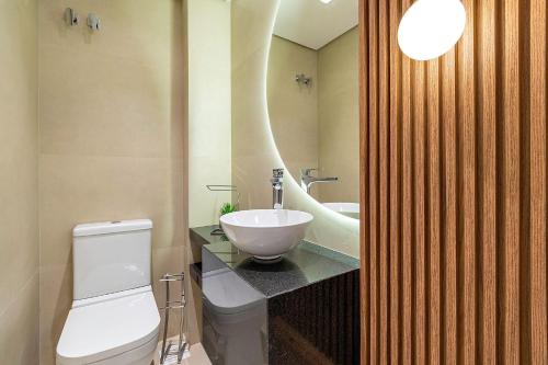 Un baño con un inodoro blanco y un lavabo. en Ap excelente Caracol - @stayhousetemporada, en Canela