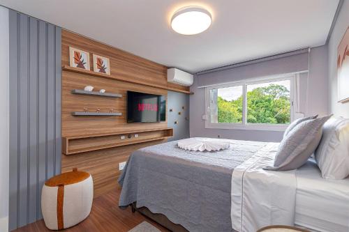 Un dormitorio con una cama y un televisor. en Ap excelente Caracol - @stayhousetemporada, en Canela