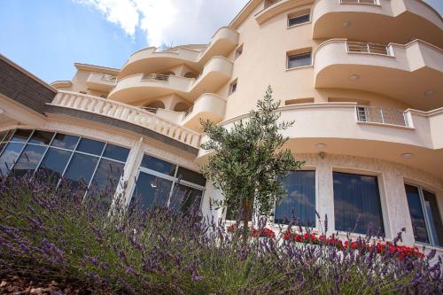 a building with flowers in front of it at Hotel Jana in Međugorje