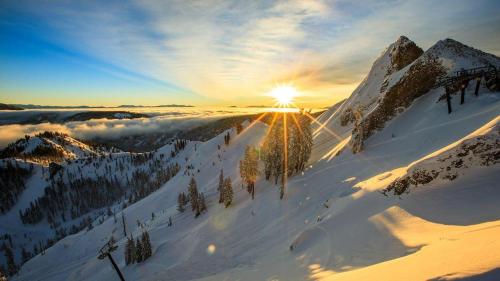 a snow covered mountain with the sun shining on it at Palisades Tahoe Lodge Rentals Two Bedroom #814 in Olympic Valley