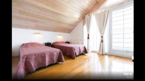 um quarto com 2 camas e uma grande janela em Chalet du Fjord & Spa em Pugny-Chatenod