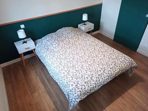 una camera da letto con un letto e due comodini con lampade di NEW : Maison - 10mn La Bourboule a Choriol
