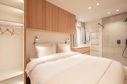 um quarto com uma grande cama branca e um chuveiro em Girasol em Knokke-Heist