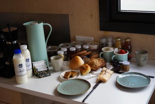 a table topped with plates of food on a counter at Slapen op de Dijk - Tiny House in Kraggenburg
