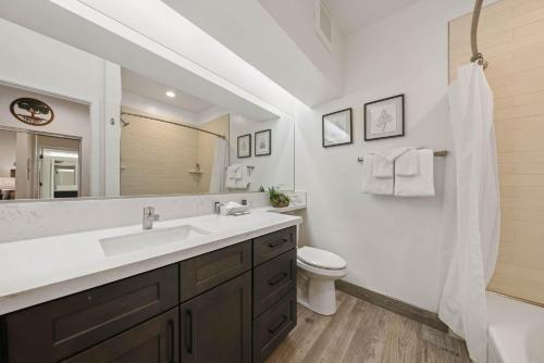 a bathroom with a sink and a toilet and a mirror at Palisades Tahoe Lodge Rentals Premium Studio #252 in Olympic Valley