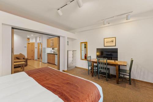 オリンピックバレーにあるPalisades Tahoe Lodge Rentals Studio #144のベッドとテーブルとキッチンのある寝室