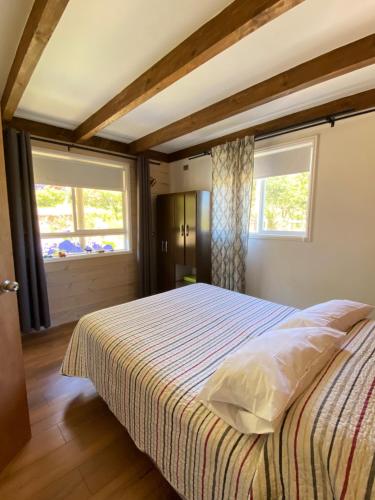 Casa Montaña في فيوترونو: غرفة نوم بسرير كبير مع نافذتين