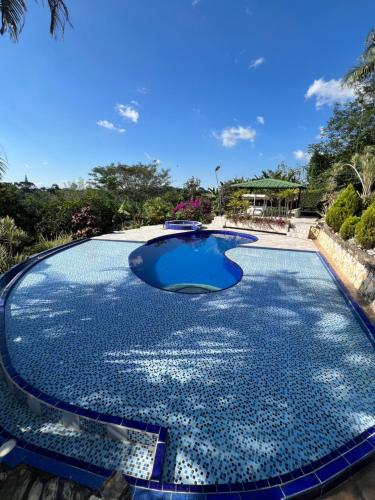 een groot zwembad met blauw water bij Finca Villa Antonella in Calarcá