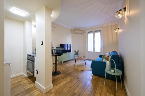 a living room with a blue couch and a table at Le Refuge Parisien in Montrouge