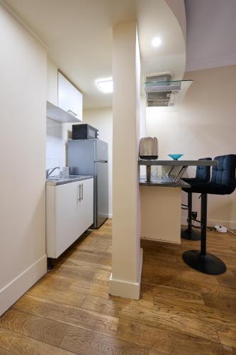 - une cuisine avec un bureau et une table dans une chambre dans l'établissement Le Refuge Parisien, à Montrouge