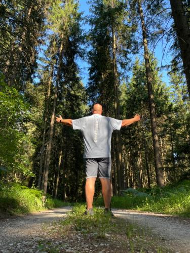 a man walking down a road with his arms outstretched at Green Oasis Garden in Šenčur