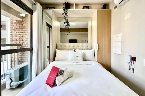 uma grande cama branca num quarto com uma janela em Zainalofts7 Moema - 1km Ibira e 200m metrô 411 ID em São Paulo