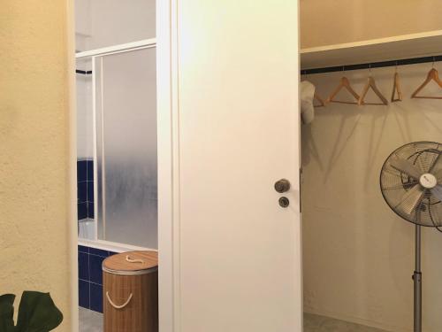 um armário com uma ventoinha e uma porta branca em Apartamento a 400 metros da praia Santa Cruz em Santa Cruz