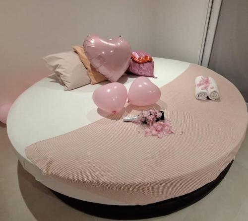 een taart met roze ballonnen op een bed bij Relax House B&B Londerzeel in Londerzeel