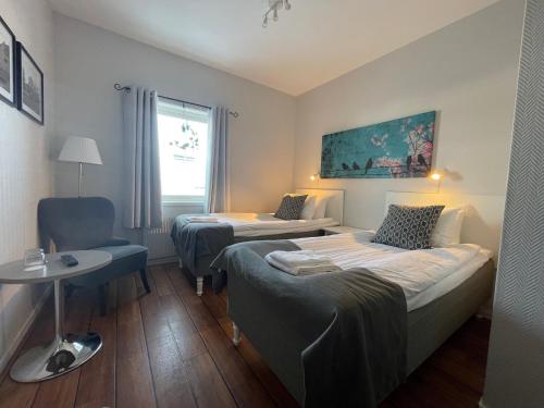 una habitación de hotel con 2 camas y una silla en Rasta Falköping, en Falkoping