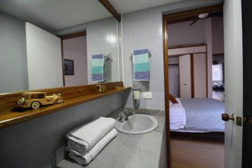 a bathroom with a sink and a mirror and a bed at Apartamento Cómodo en el Poblado in Medellín