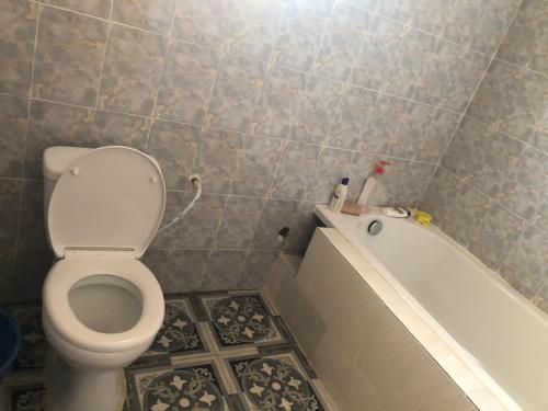 ein Badezimmer mit einem WC und einer Badewanne in der Unterkunft 3 bedrooms first story apartment in Sukuta