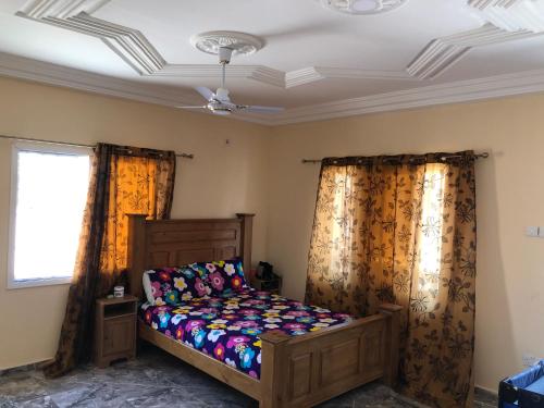 a bedroom with a bed and two curtains at 3 bedrooms first story apartment in Sukuta