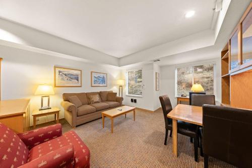 a living room with a couch and a table at Palisades Tahoe Lodge Rentals Studio #118 in Olympic Valley