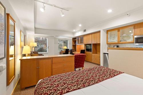 a bedroom with a bed and a desk and a kitchen at Palisades Tahoe Lodge Rentals Studio #118 in Olympic Valley