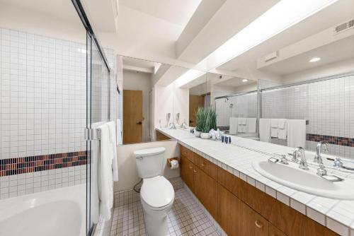 uma casa de banho com WC, 2 lavatórios e um espelho. em Studio #118 em Olympic Valley
