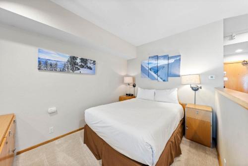 a small bedroom with a bed and two paintings on the wall at Studio #207 in Olympic Valley