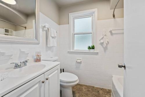 biała łazienka z toaletą i umywalką w obiekcie Classic Charm with Modern Flair w mieście Homewood