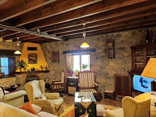 a living room filled with furniture and a tv at Heredad de la Cueste in Llenín