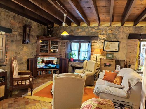 a living room filled with furniture and a stone wall at Heredad de la Cueste in Llenín