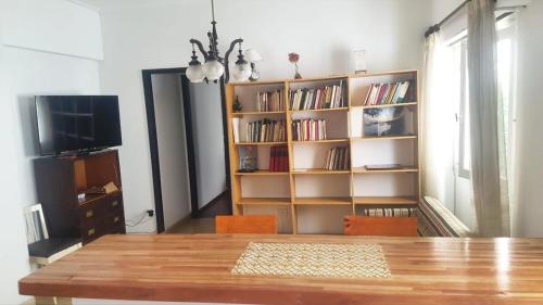ein Esszimmer mit einem Tisch und einem Bücherregal in der Unterkunft Departamento Céntrico in Mar del Plata