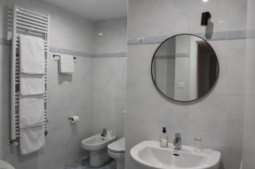 Baño blanco con lavabo y espejo en Monasterio Centro Histórico, en Burgos