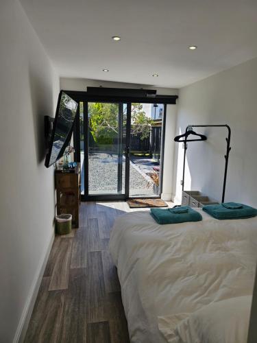 um quarto com uma cama e uma porta de vidro deslizante em The Cute Cabin em Santon