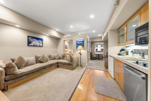 a living room with a couch and a kitchen at Palisades Tahoe Lodge Rentals Studio #211 in Olympic Valley