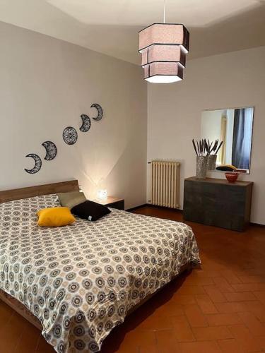a bedroom with a bed with a yellow pillow on it at Appartamento Ilesis in San Casciano in Val di Pesa