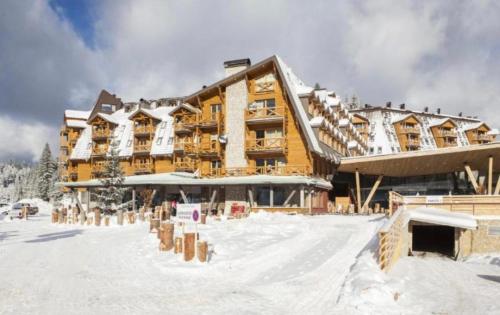 a large building in the snow in front at Apartment vucko C248 in Jahorina