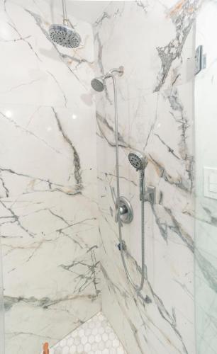 a bathroom with a shower with marble walls at Blanquitas Home in Long Beach