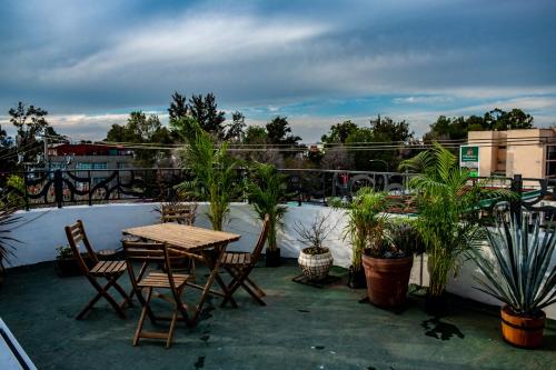 a patio with a table and chairs and potted plants at Modern Studio, Rooftop Charm, CDMX Center2 in Mexico City